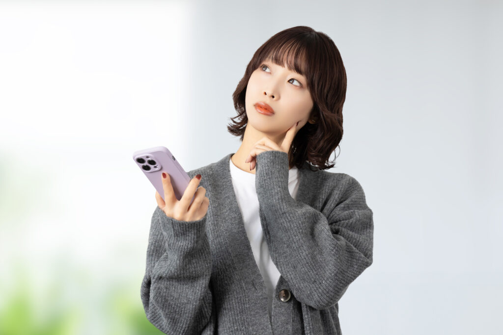 スマホを見て考える女性